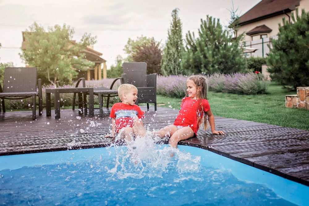 Kids splashing their feet in the pool.