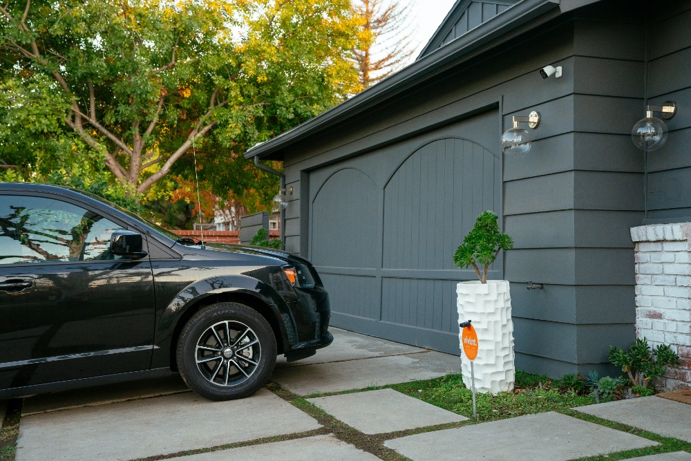 Car parked in front of a closed garage door.