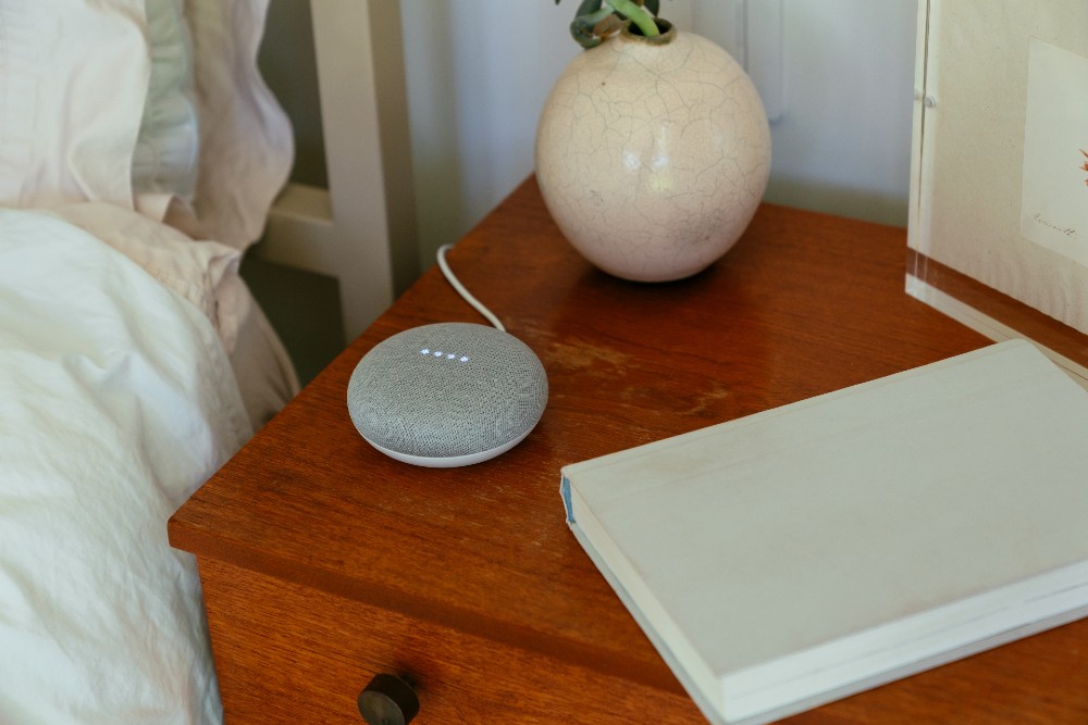 Google mini speaker on bedside table.