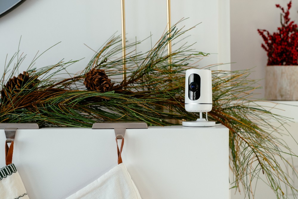 Vivint Indoor Camera sitting on a fireplace decorated for Christmas.