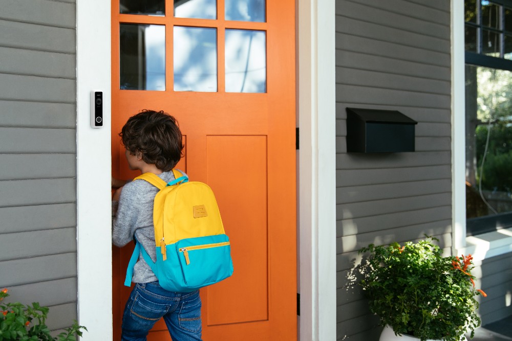 Child walking in their front door with the Vivint Doorbell Camera in view.