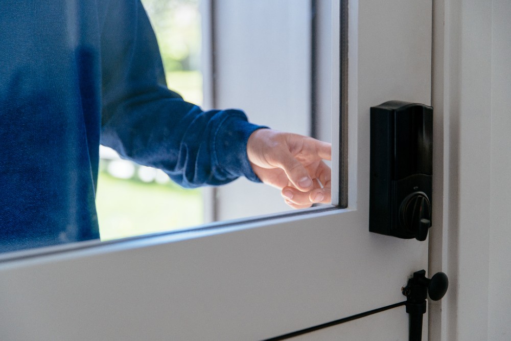 A view of someone's hand unlocking an automatic door lock.