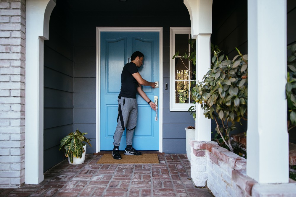 Man locking his front door as he leaves for a run.