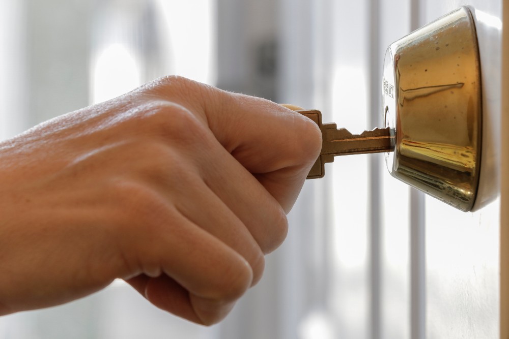 Close-up of a person's hand locking their front door.