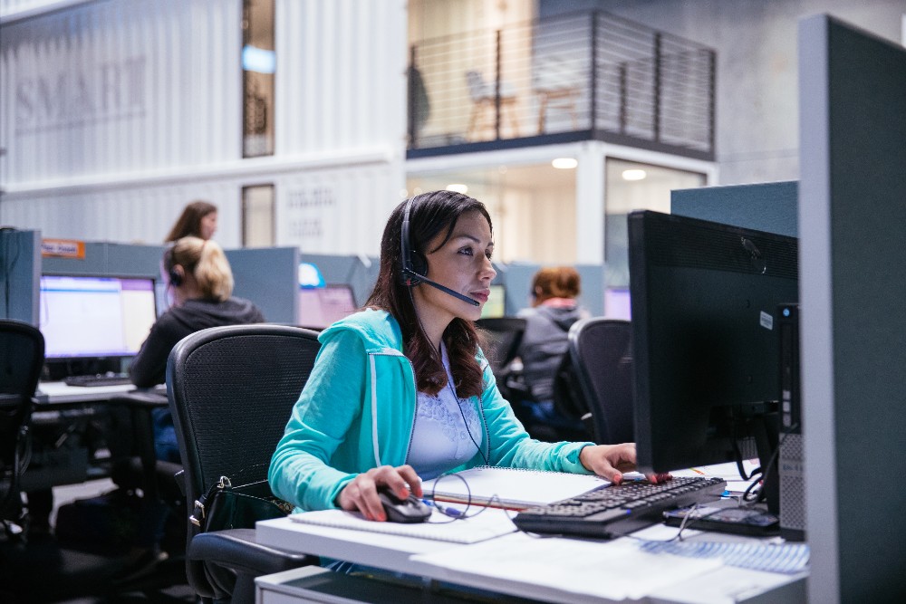 Woman talking into a headset in a Vivint monitoring center.