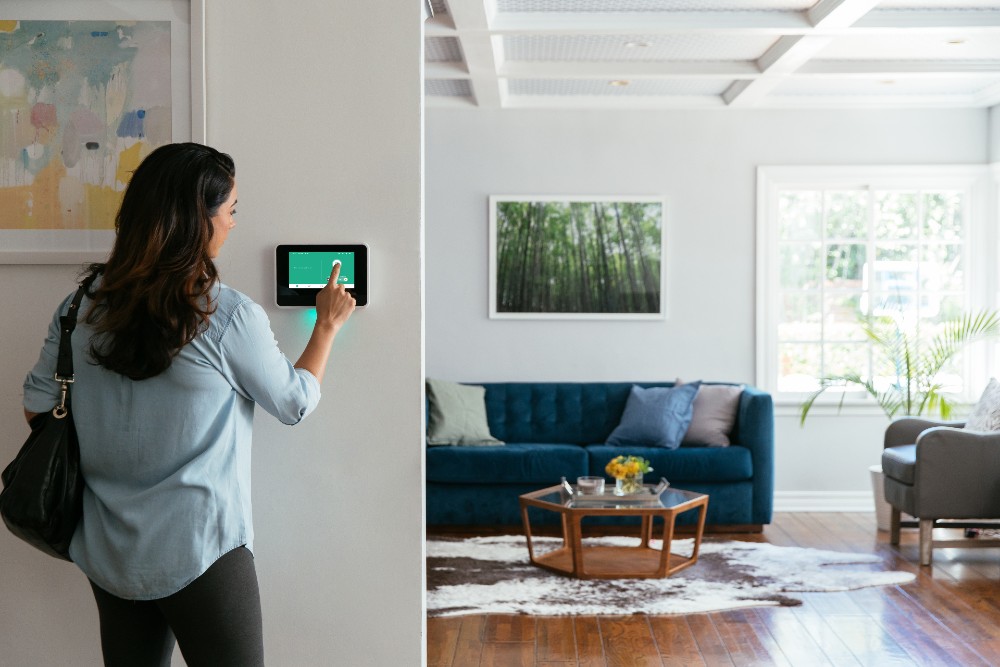 Woman arming her Vivint Smart Hub before leaving the house.