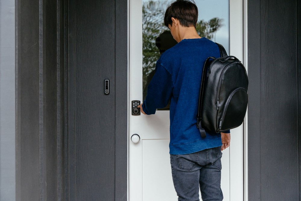 Teenager unlocking his home's smart door lock.
