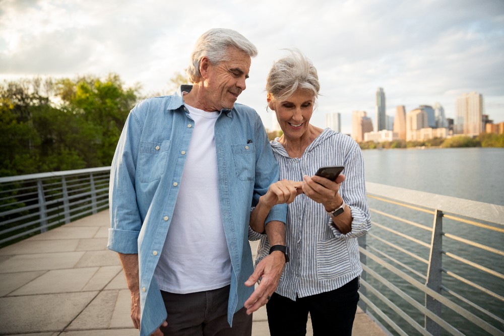 An elderly couple checking the Vivint app while out on a walk.