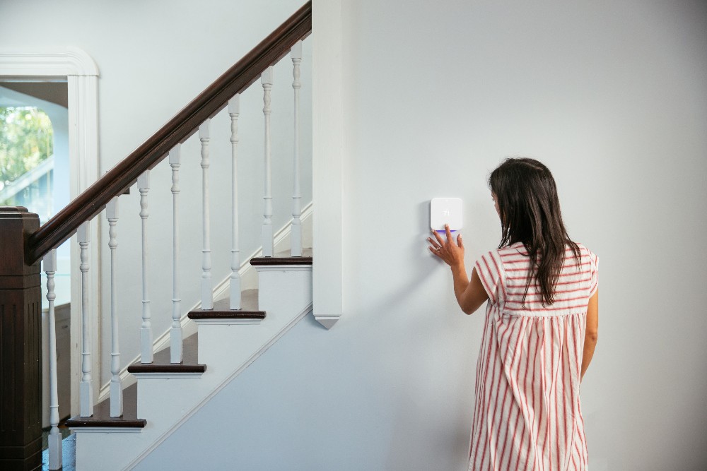 Woman turning down the temperature on her Vivint Thermostat.