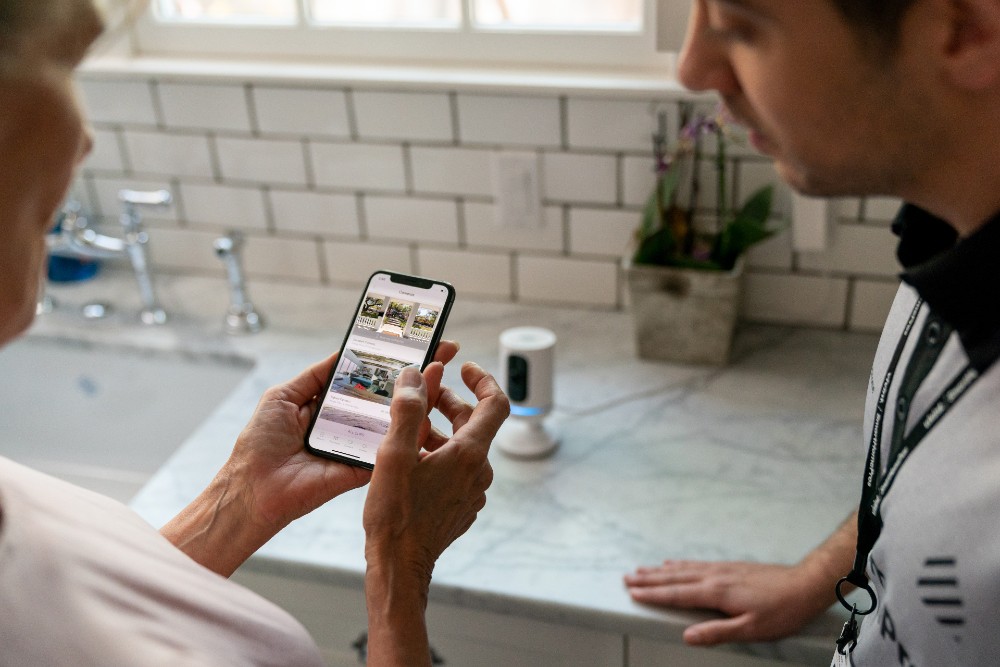 Woman viewing security camera footage from the Vivint app.