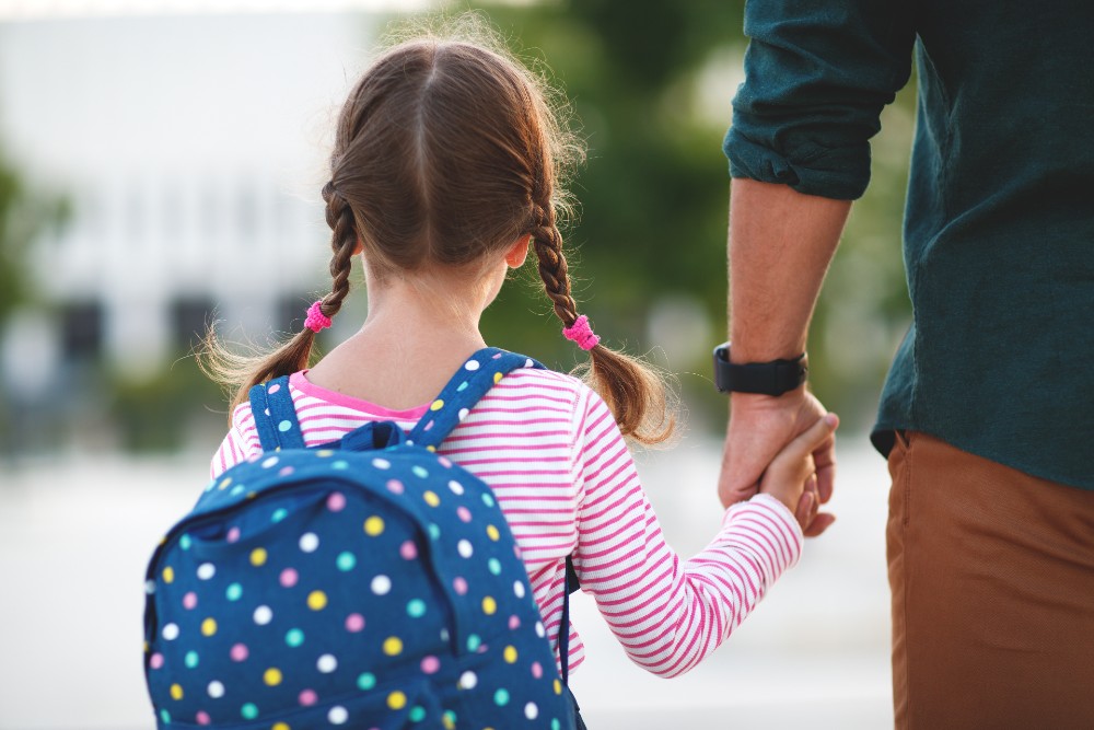 A father walking his child to school.