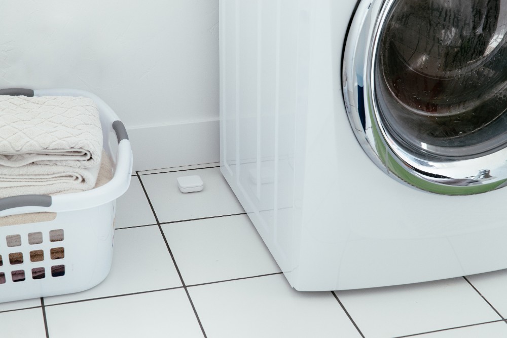 Vivint water sensor next to the washing machine.