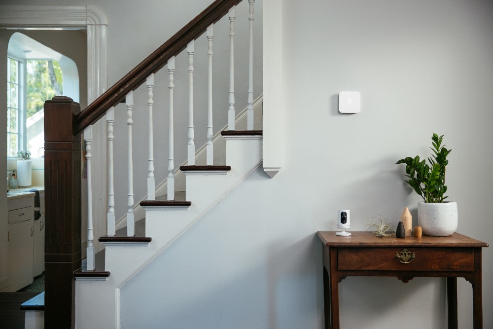 A smart thermostat and Vivint Indoor Camera in a home.