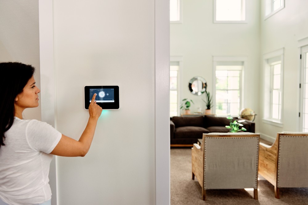 Person arming smart hub and view of the living room