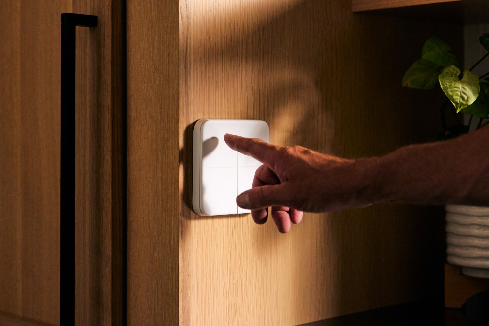 Person adjusting lights with smart light switch