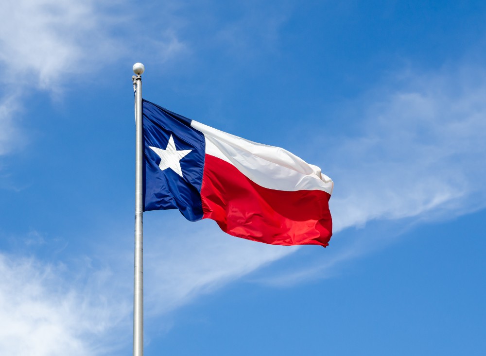 Texas state flag with blue sky and some clouds