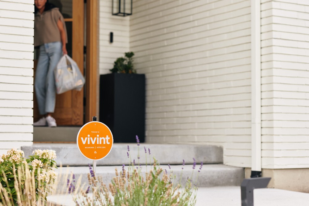 Vivint sign and person walking out the front door