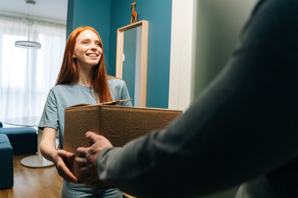 Woman receiving a package delivery at her apartment