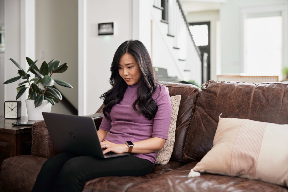 Woman on her phone in her living room.