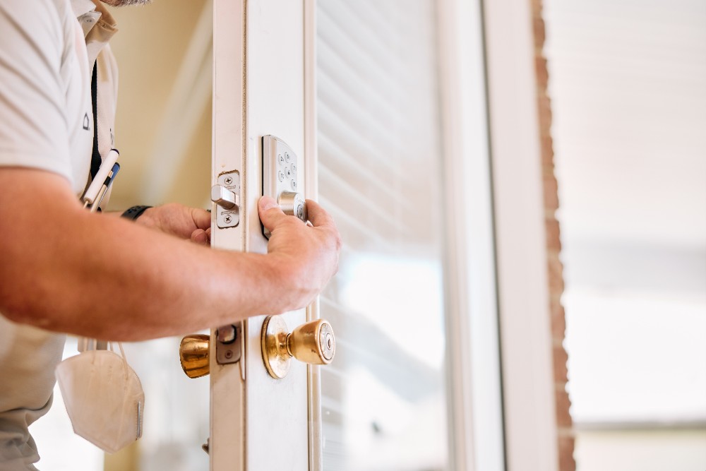 Vivint smart home tech installing a smart door lock.