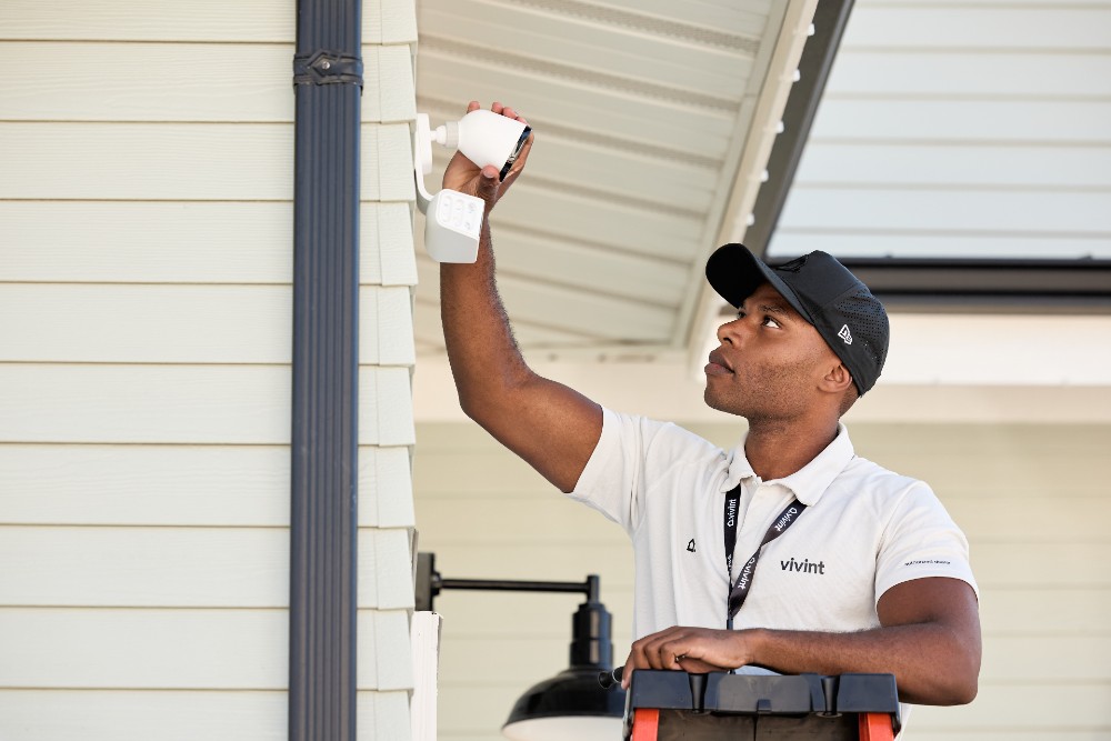 Vivint smart home technician installing an outdoor security camera.