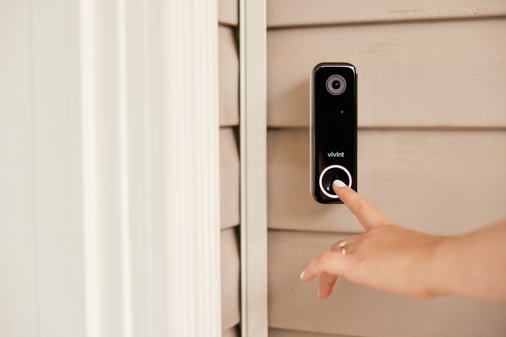 Woman ringing a Vivint doorbell camera.