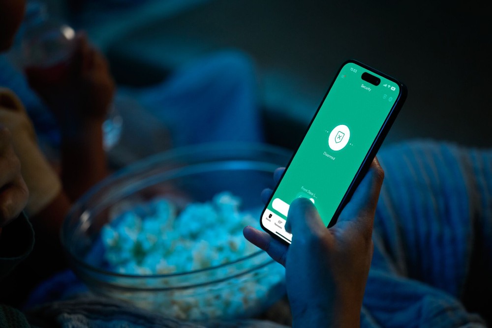 Person checking the Vivint app at night.