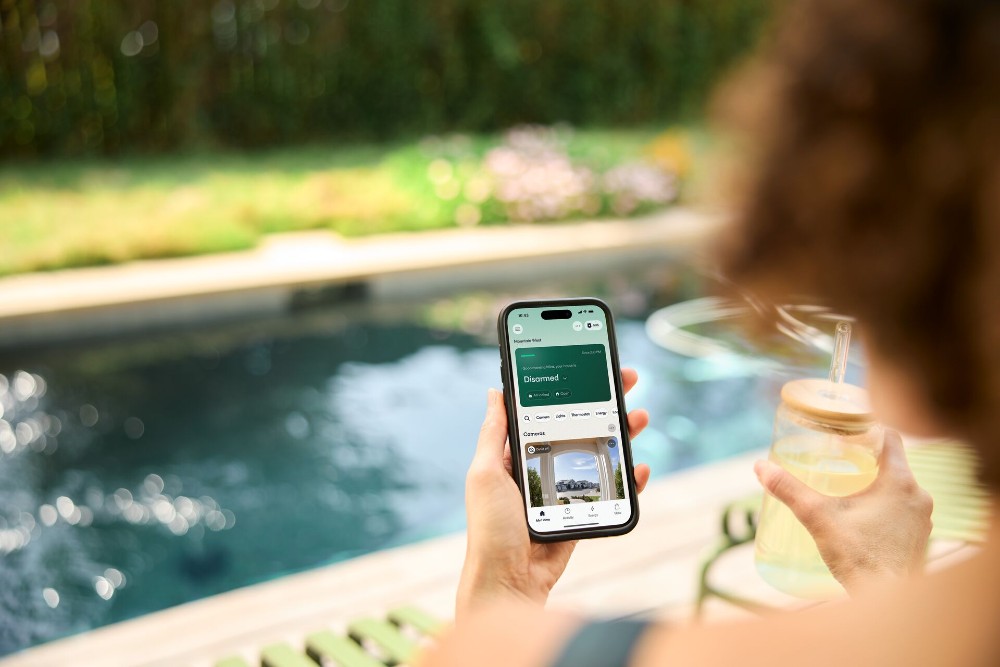 Woman checking her Vivint app while at the pool.
