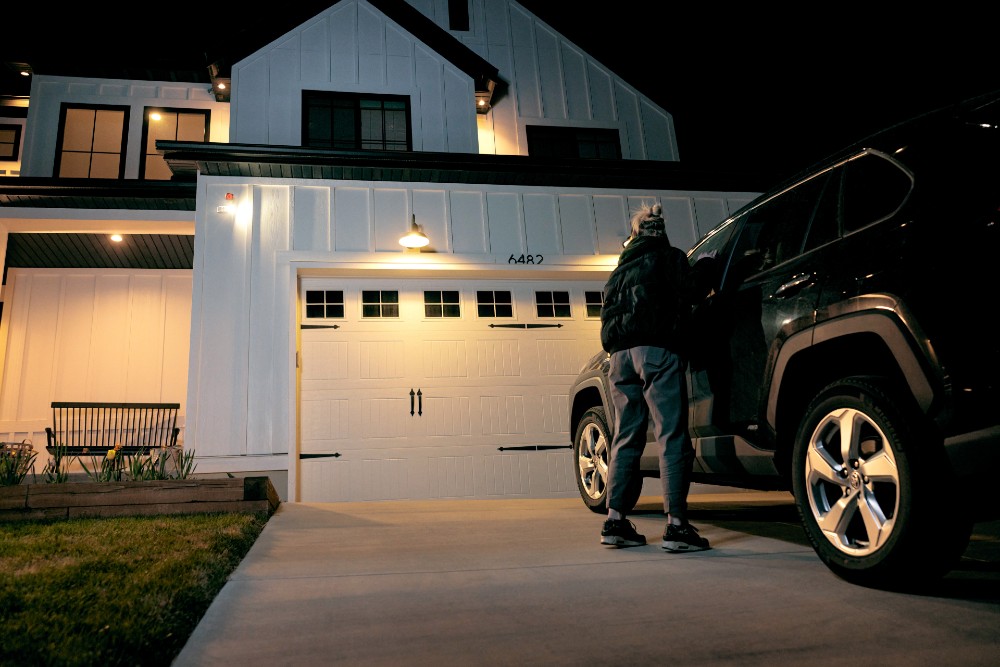 Man breaking into a car in the driveway.