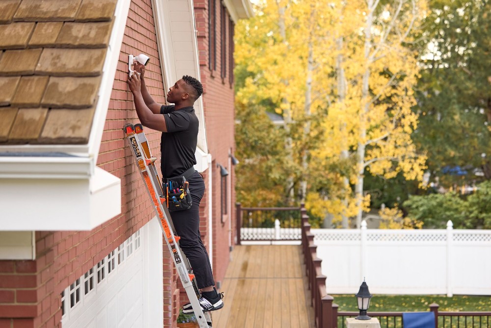 Vivint installer on a ladder.