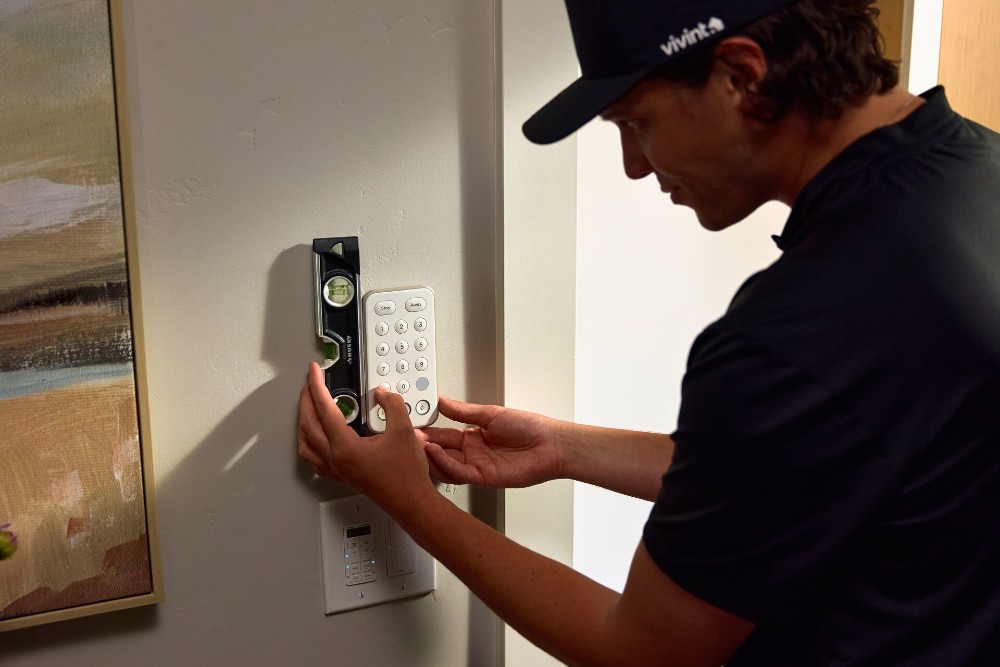 Vivint installation tech making sure devices are level.