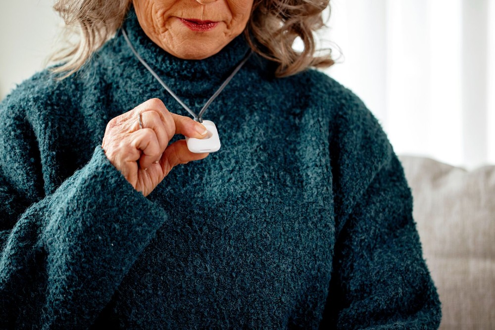 Woman wearing a Vivint panic pendant.