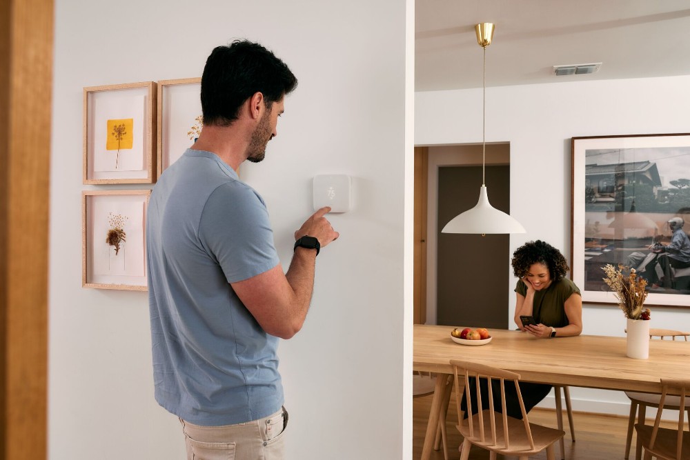 Person adjusting their smart thermostat.