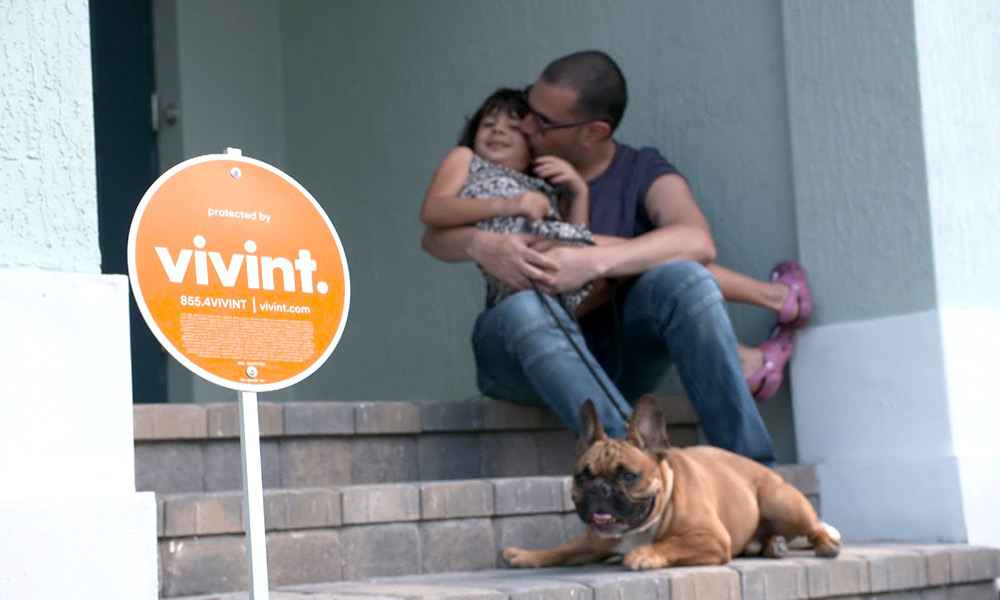 Vivint Sign in a yard with a family in the background