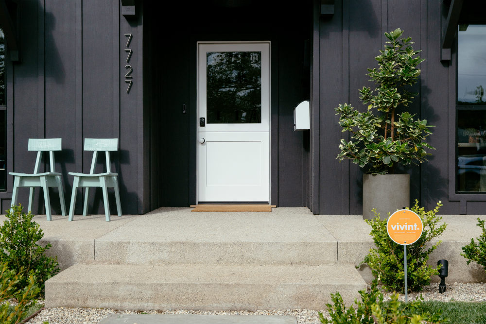 Vivint protected home with a sign in the yard and a smart lock at the door