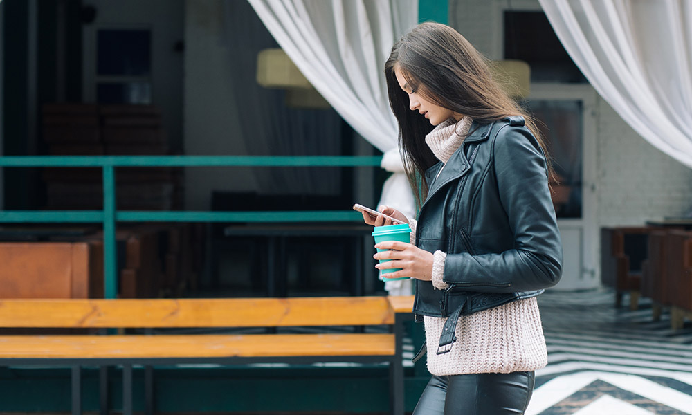 millennial woman texting and walking