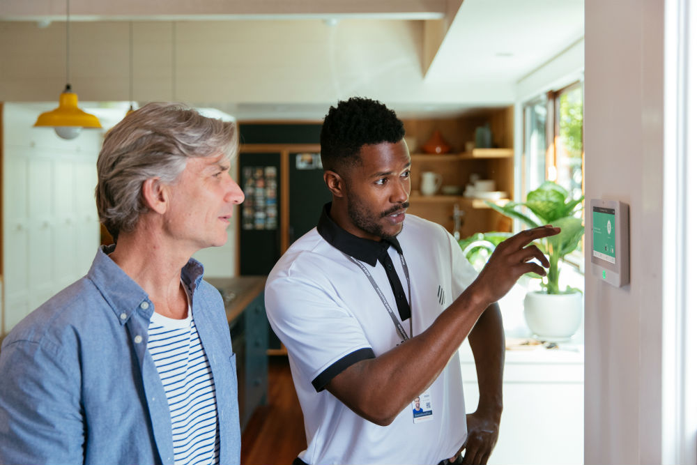 Vivint professional showing a man how to use the Vivint Smart Hub