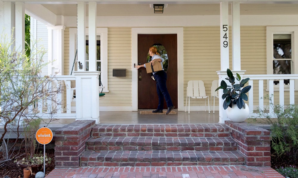 A delivery person rings a Vivint Doorbell Camera