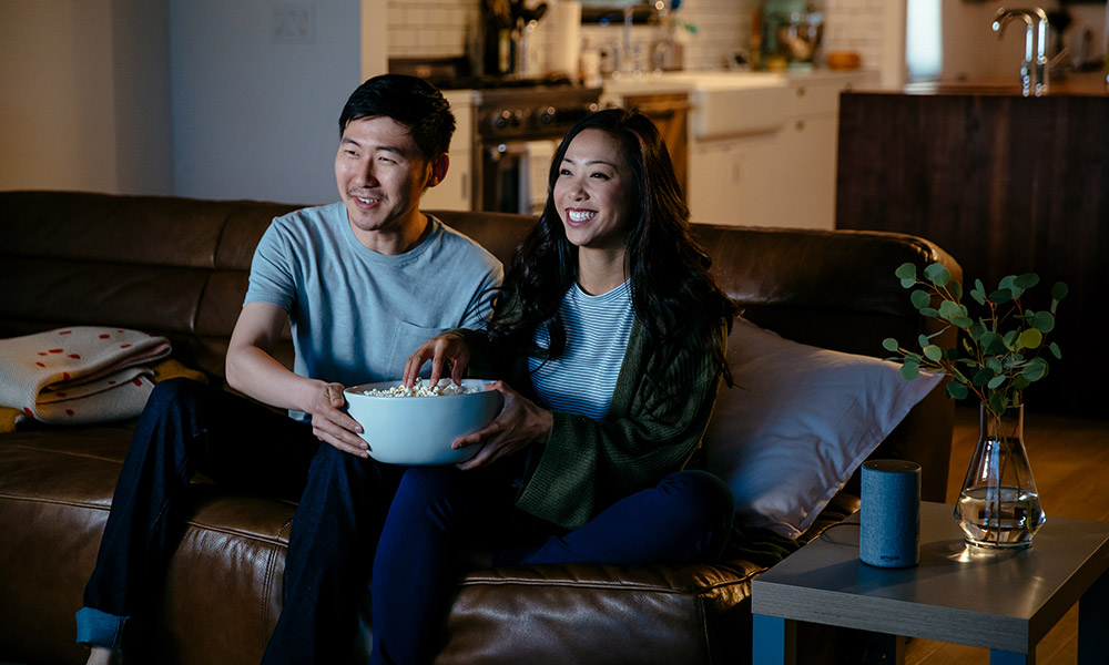 couple watching a movie with amazon echo on a side table