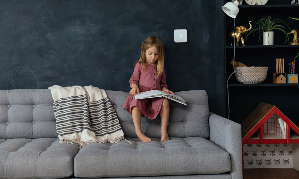 Vivint Smart Thermostat thermostat and girl sitting on a couch