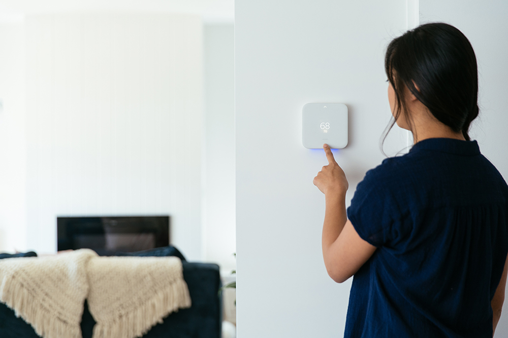 Woman using Vivint Smart Thermostat