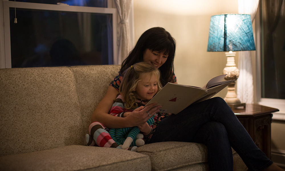 A mom reads to her child next to her smart lights