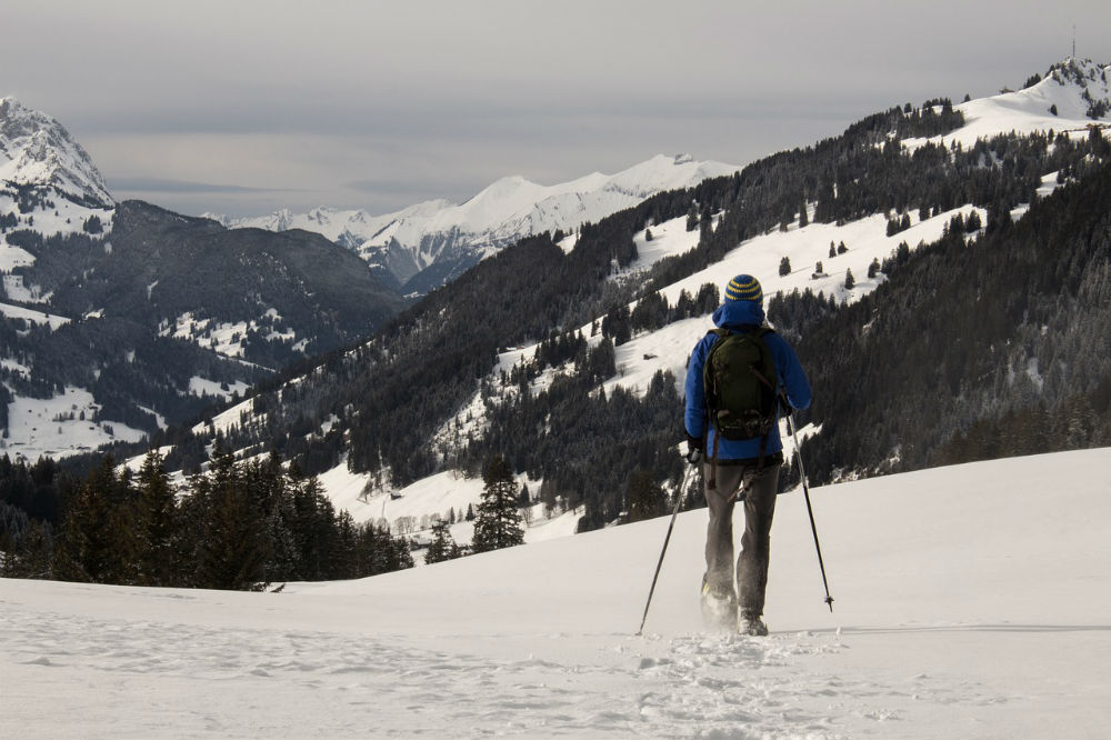 man snowshoeing mountains