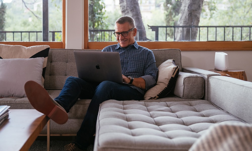 Guy using a Mac laptop to access his Vivint camera recordings