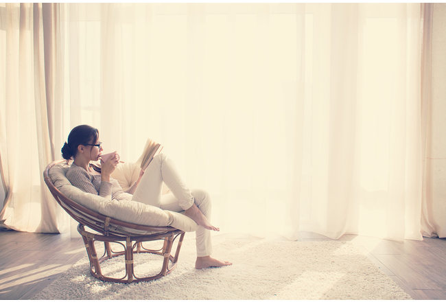 Lady sitting in a living room reading a book
