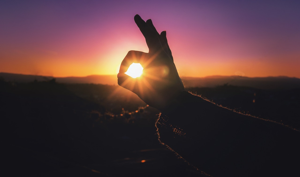 Hand In Front Of Sunset Background 